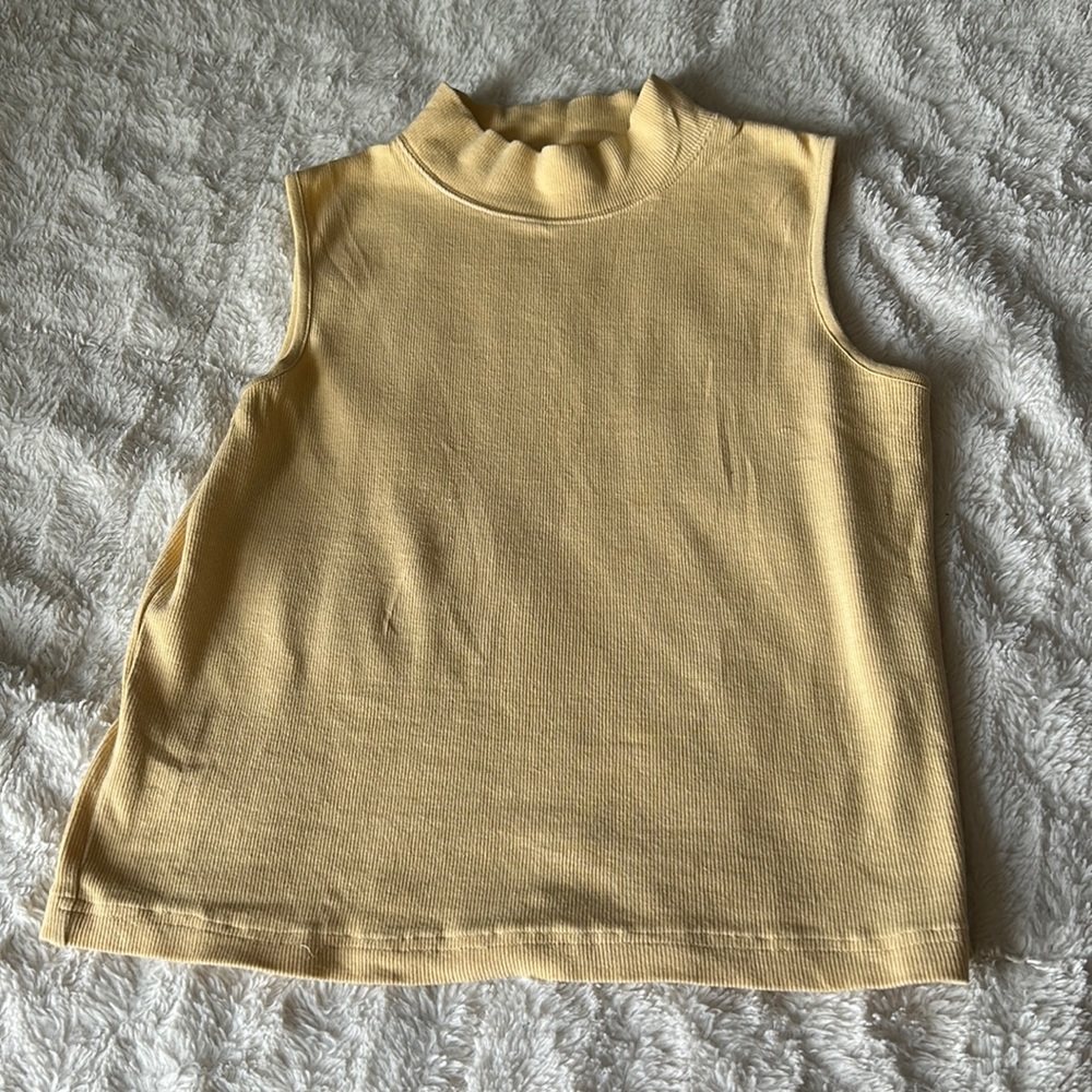 A pastel Yellow crew neck sleeveless top.